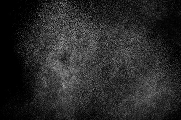 Abstract splashes of water on black background. Freeze motion of white particles. Rain, snow overlay texture.