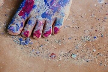 Crop model with colorful feet standing on dirty floor