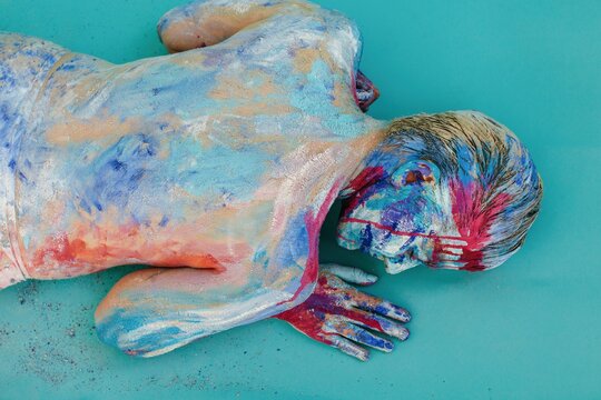 Model with painted body lying on belly