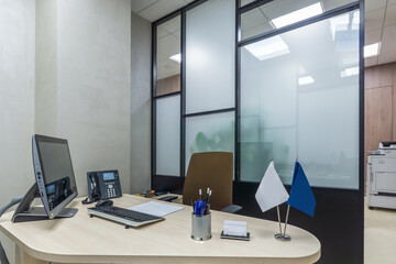 Workplace close view, with the computer, telephone on desk. Modern sales office with a copy machine