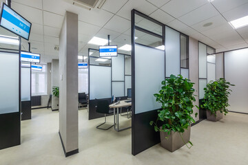 Modern cubicle office with high  black and white glass panels  and digital signages. New sales office