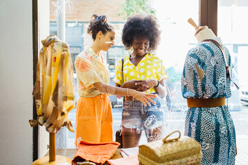 Two friends shopping in a vintage clothing store.