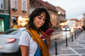 profile smiling woman reading a message on her phone.