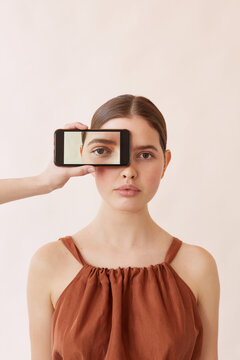 Young Model With Her Eye On Smartphone Screen