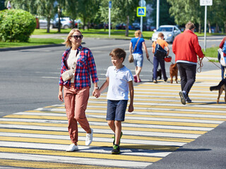 Woman and child cross road at crosswalk