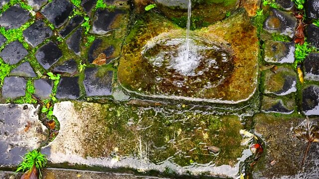 Marble basin with water flowing from a typical public cast iron fountain seen from above, known by Roman citizens as Nasone