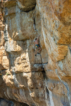 Climber on yellow rocky wall
