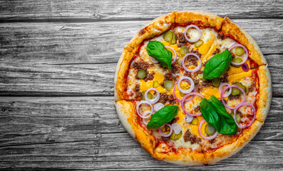 Pizza with Mozzarella cheese, Bolognese sauce, minced meat and vegetables. Italian pizza on wooden background.