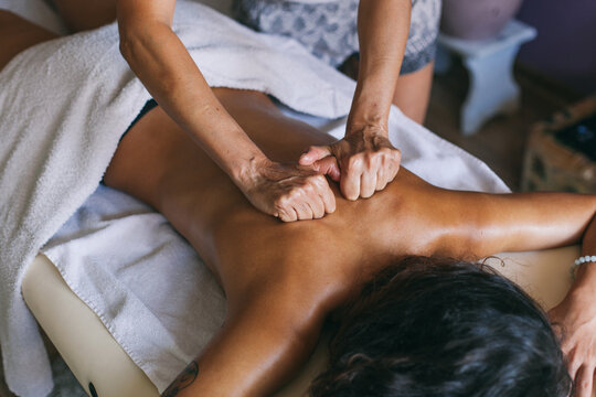 Masseur doing massage of female back indoor