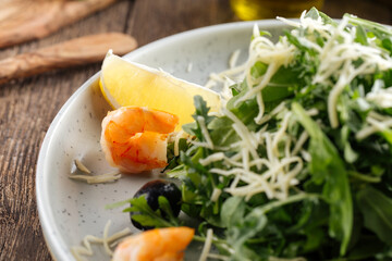 Fresh arugula salad with shrimps and olives