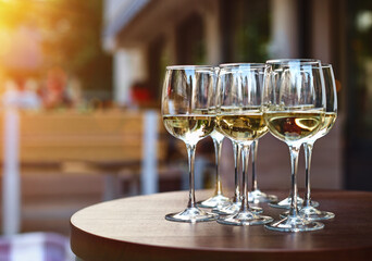 White wine tasting on winery terrace, pouring of cold dry wine in glasses outdoor in sunny day
