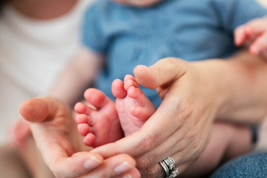 Family: Mother Holds Baby Girl's Feet In Hands