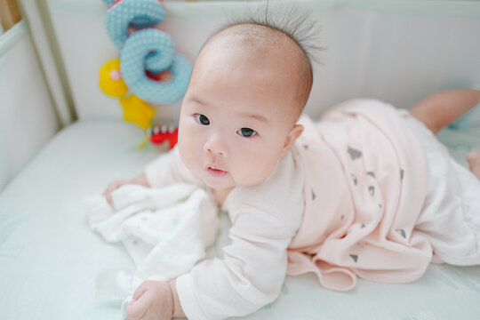portrait of cute baby girl lying on bed