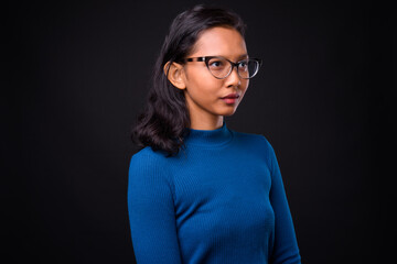 Portrait of young beautiful Asian businesswoman with eyeglasses