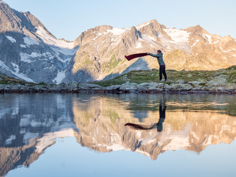 Yogi rolling out mat in the mountains
