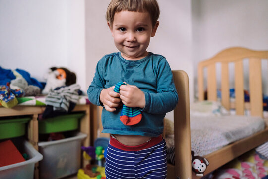 Cute toddler boy with sock in playroom