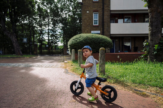 Boy with bicycle at sidewalk