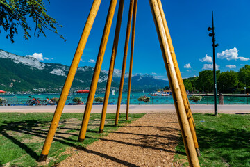 View of Annecy lake, boats with tourists and Alps mountains on sunny day with blue sky in Annecy city.Annecy is the largest city of Haute-Savoie department in France.