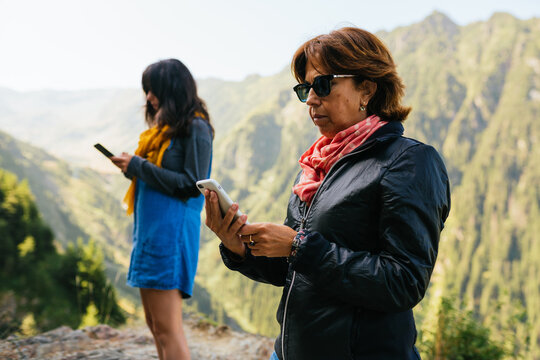 Mother and daughter ignoring each other and using their phone