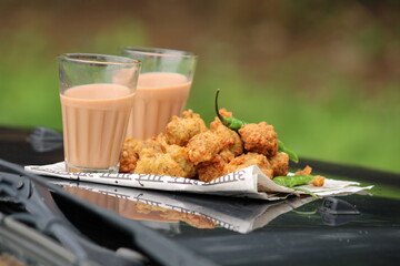 Crispy moong pakora, delicious street food, favourite indian snack in monsoon served with Hot Tea.Kept on car's bonnet