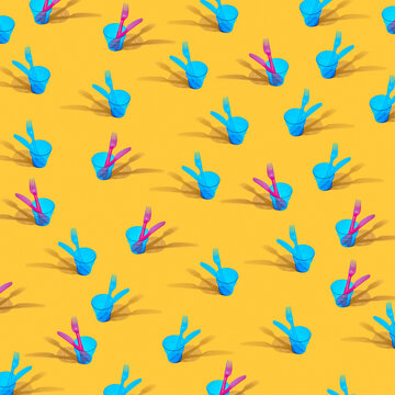 Colorful plastic dishware pattern on yellow.