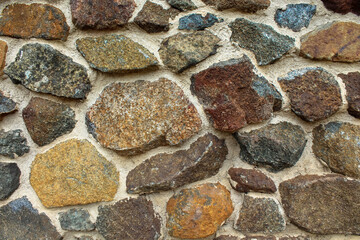 Background image of a textured multicolored stone wall 