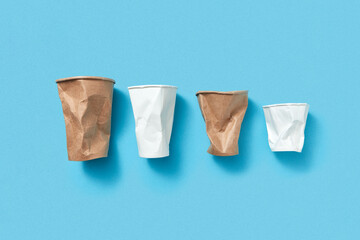 Crumpled paper cups on blue.