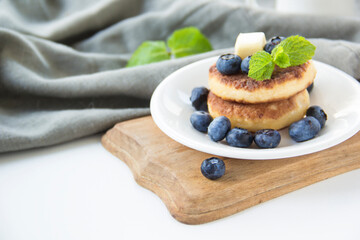 A healthy breakfast of pancakes, berries, butter, and honey.