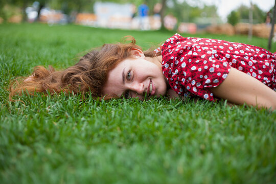 woman lying at graas and looking at camera