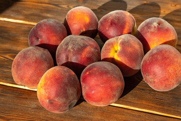 many ripe peaches on a wooden background