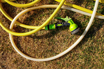 Green and yellow hose  on the dry grass