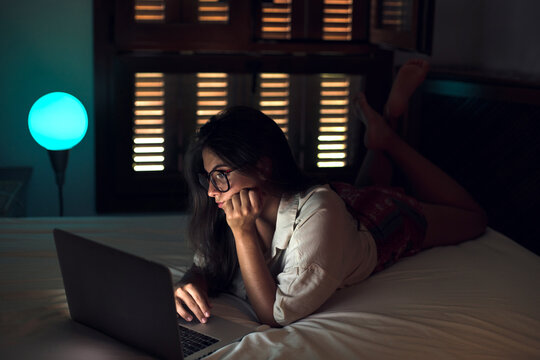 Woman at night working on laptop