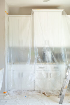 Plastic Sheets Cover Cabinets As Painters Prep To Paint A Modern Kitchen.