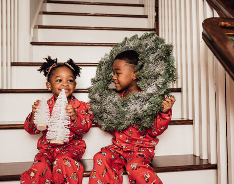 Family taking Christmas pictures on the stairs in matching pajamas