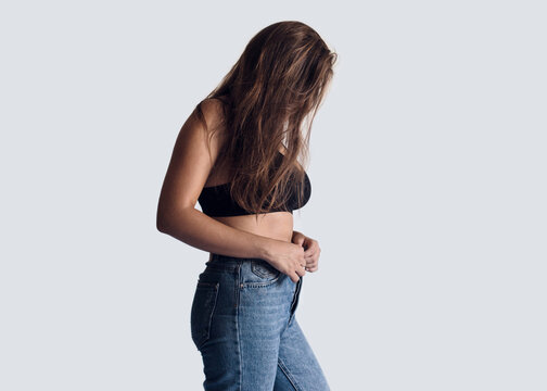 Unrecognizable woman buttoning her jeans