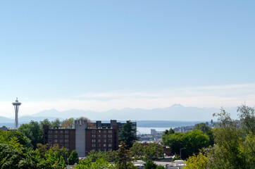 Panoramic view of the Olympic Mountain Range across from Seattle and partial view of a Seattle neighborhood with Space Needle on the left.