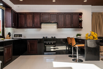 Interior design of house, home, villa feature contemporary kitchen with wooden brown cabine, range hood, oven and appliance