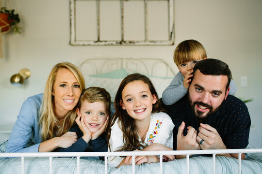 Family Cuddling on Bed