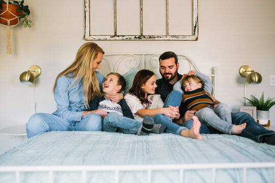 Family Cuddling on Bed