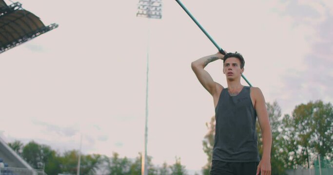 Run-up and javelin throw at the stadium. Slo-Mo Shot of Young Man Throwing Javelin. One caucasian man javelin thrower on stadium