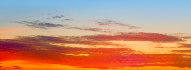 orange sunset sky panorama landscape background. Panoramic cloudscape at dusk. Mellow sunrise ultra wide view. Natural color of summer evening nature with sun below horizon