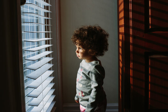 Kid looking through window blinds