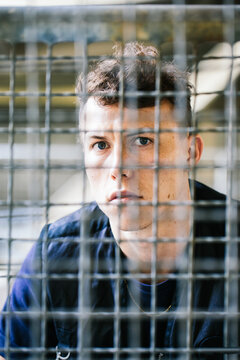 Young Man Behind Metal Bars