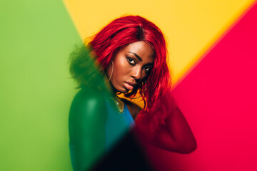 Beautiful Woman posing over yellow background with green and red gels