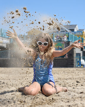 Summer Girl Throwing Sand