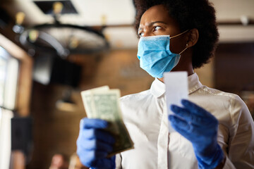 Black waitress feeling displeased about the tip from a customer.