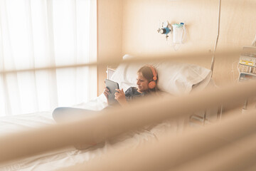 Little patient in hospital bed using a tablet. Medical concept