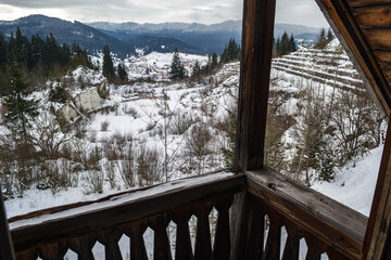 Mountain landscape view from a wooden balcony during winter. Mountains covered by snow