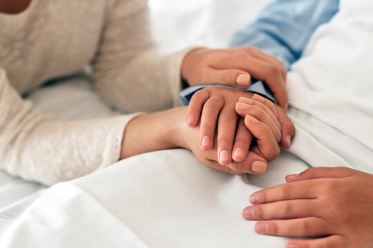 Mother and daughter holding hands in a hospital