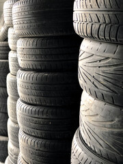  A lot of old used tires are lying on top of each other. Replacing winter and summer tires. Seasonal tire replacement concept